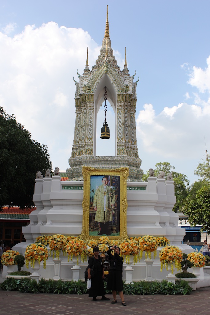 A portrait of King Bhumibol Adulyadej inside the Wat Pho temple complex. Note the folks in front, dressed in black.