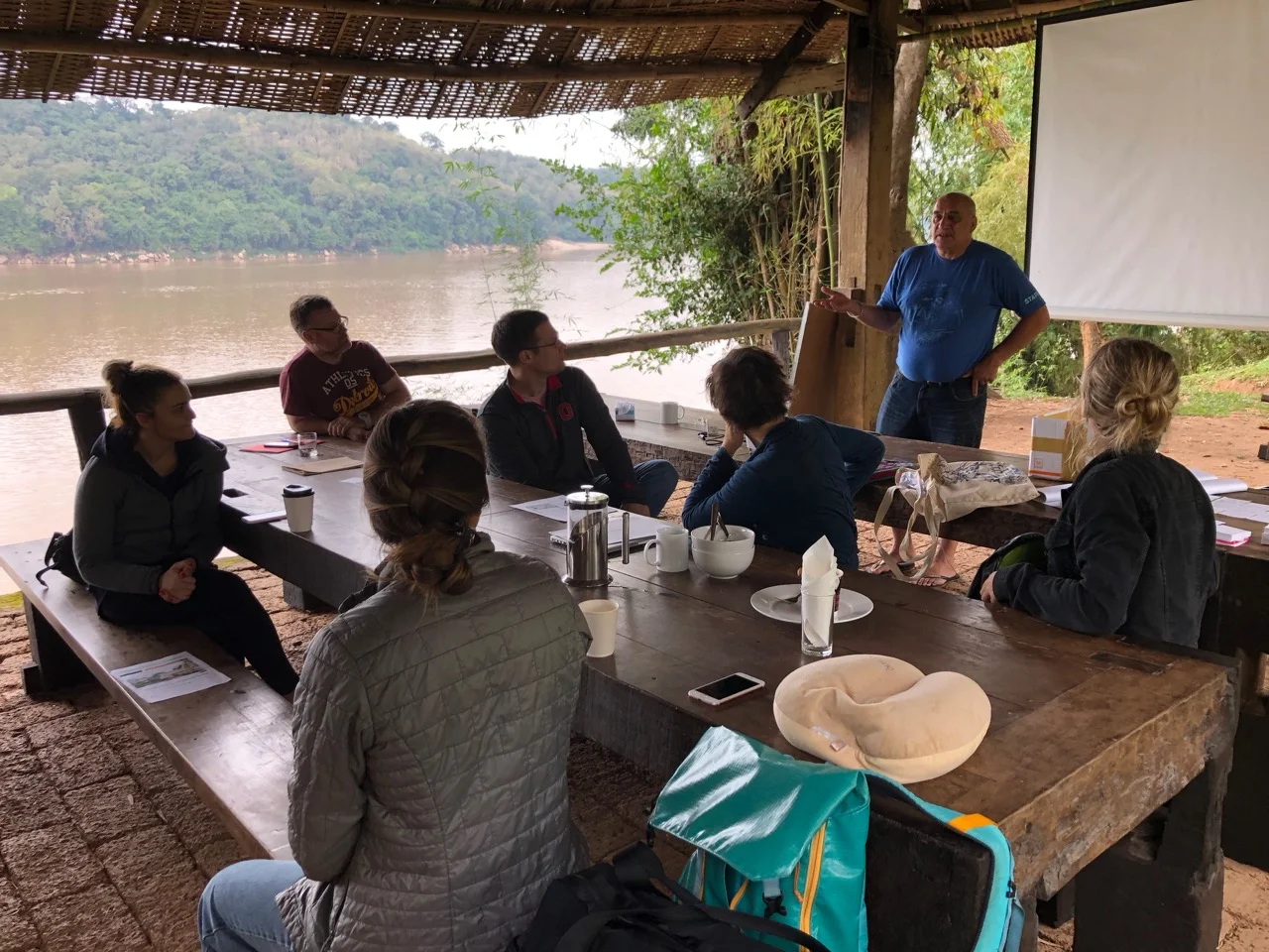 Our fearless leader Les debriefing us in the riverside lodge after the service learning experience (see below)