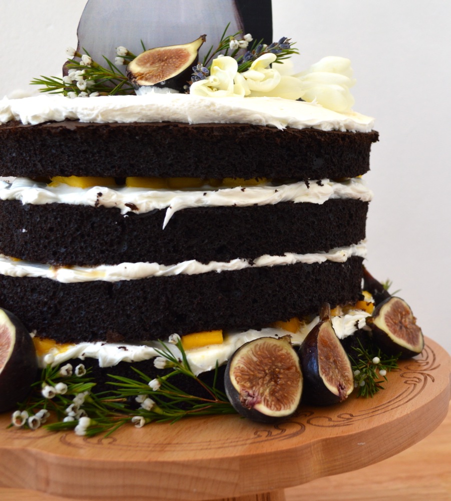 Position cake topper and then adorn the top and bottom of cake with fresh flowers and sliced figs.