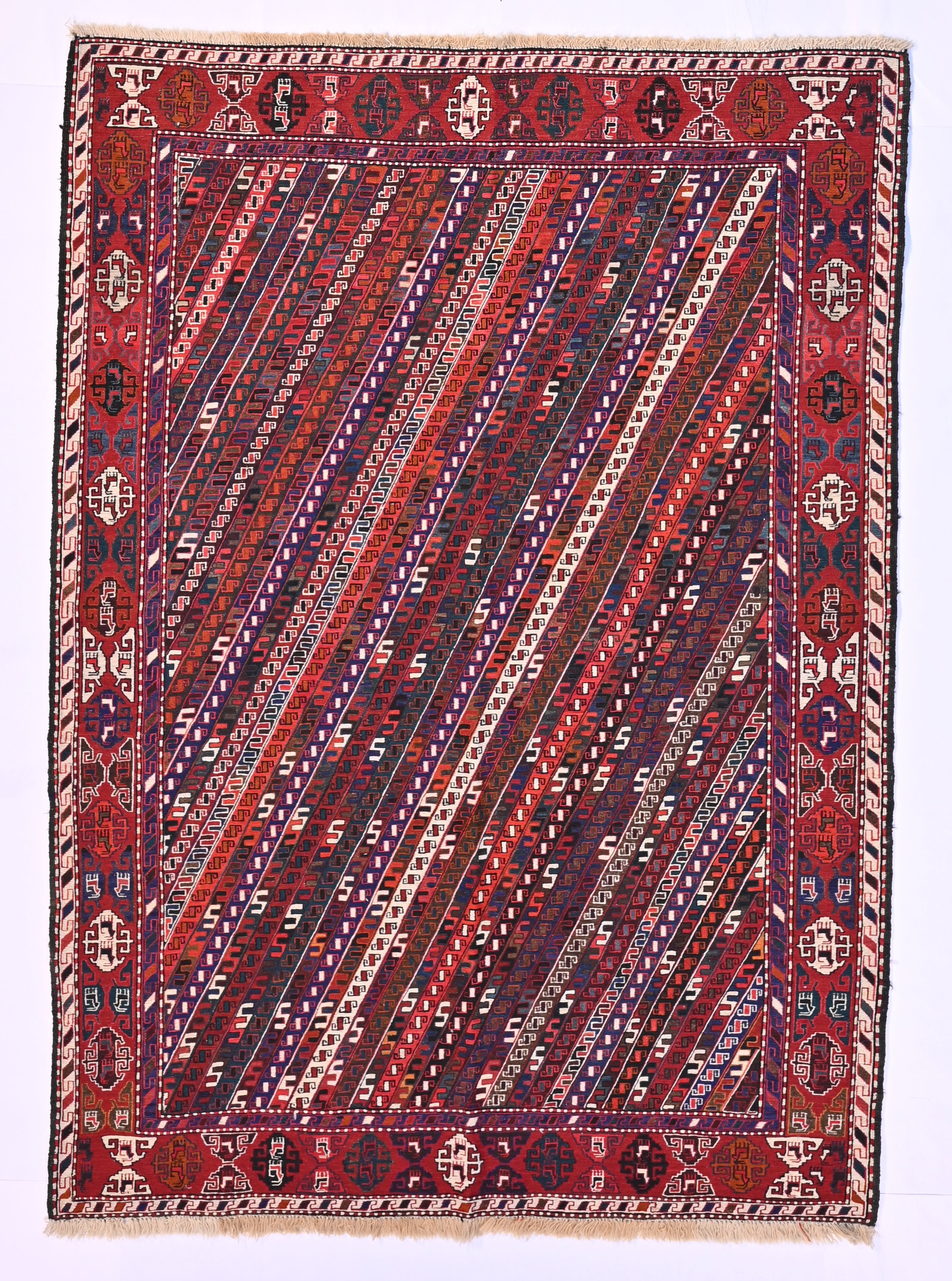 Azerbaijani sumak 50612, with narrow diagonal bands of small geometric motifs and a rich red border, 197 by 140 cm.