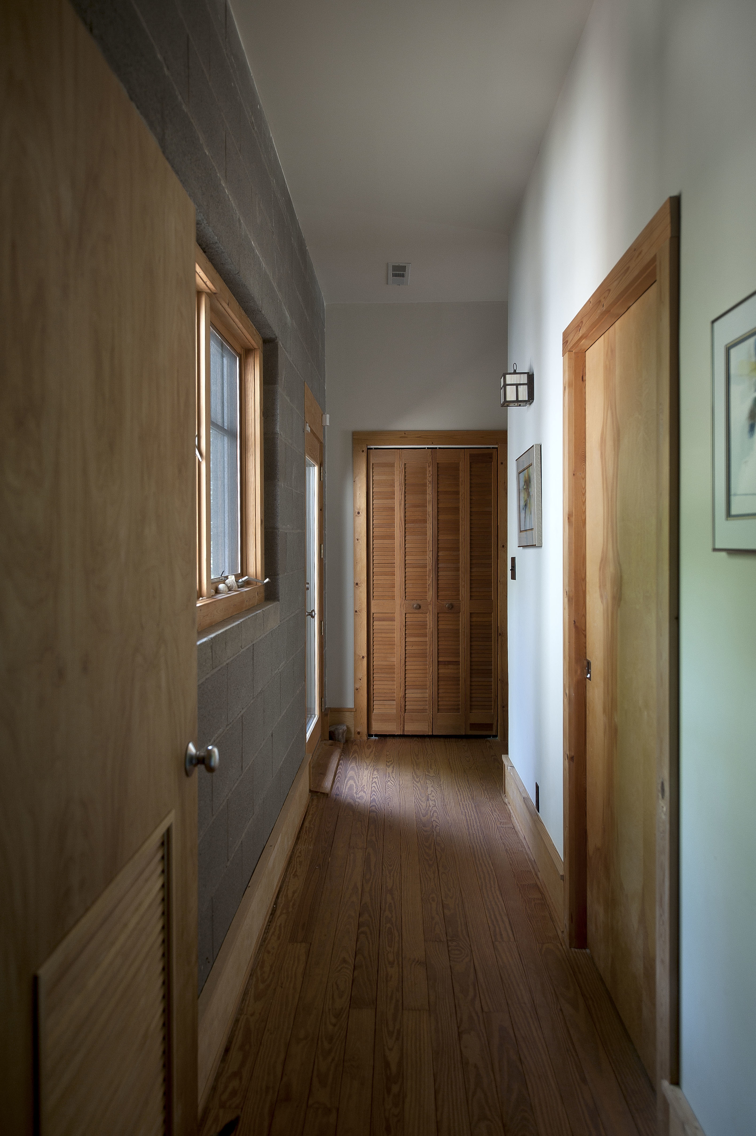 Custom woodwork, doors, and windows enhance the hallway to the office.