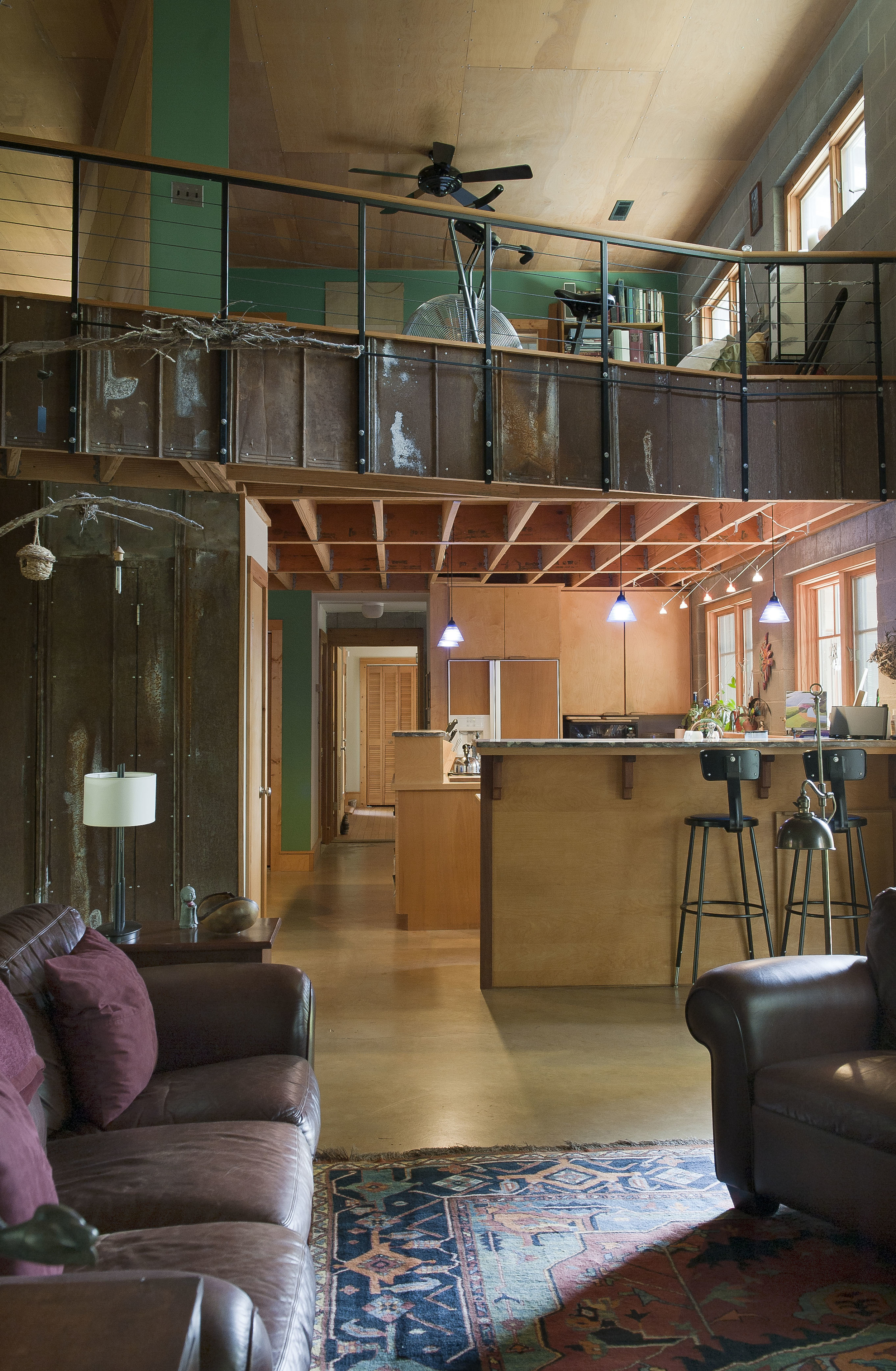 The rustic master bedroom balcony and openness of the living and kitchen areas enhances the "loft" design.