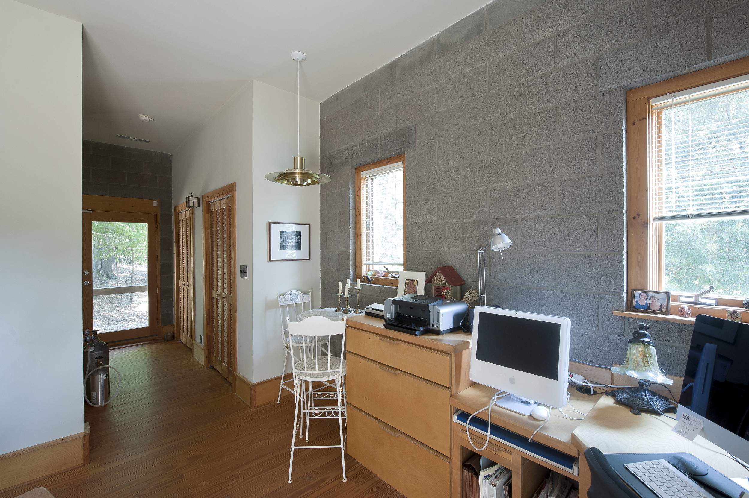 The office, separate from the open living area, is a quiet and bright space.