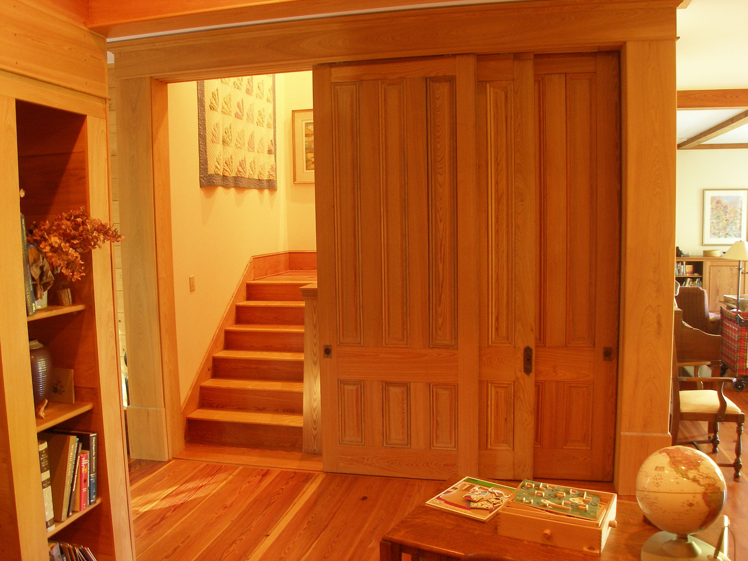 Tall cypress doors open showing stairs to guest bedroom and tower.