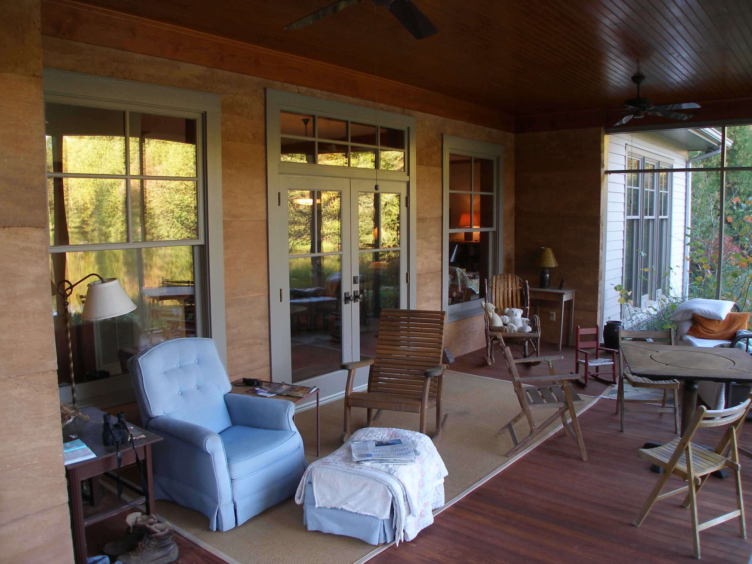 Screened in porch with rammed earth walls.