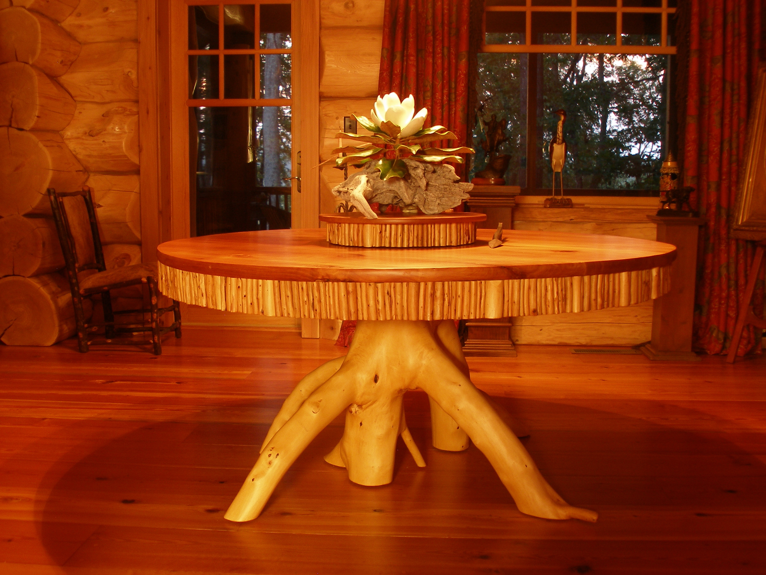 Dining table in red cedar with applied twig apron and natural yellow cedar crotch pedastal.