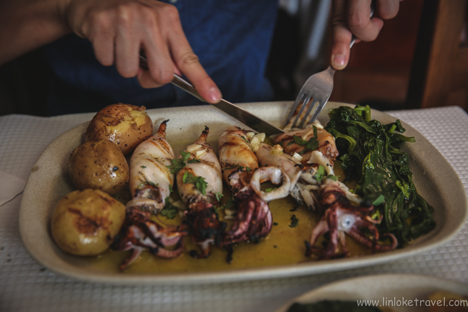 Food in Portugal/ Delicious grilled squid with a side of potatoes and greens. 
