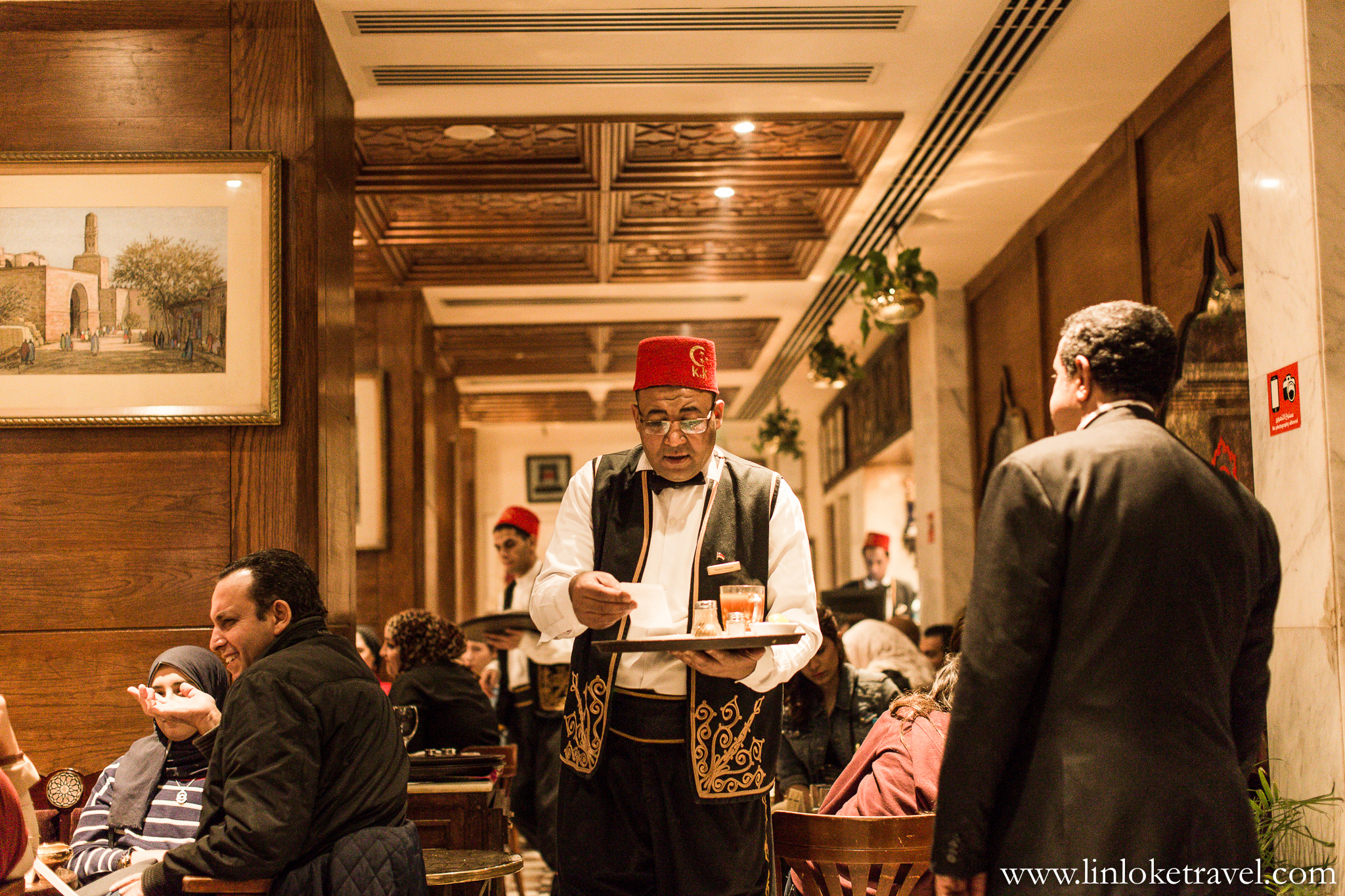 The waiters at Naguib Mahfouz Cafe are all clad in traditional uniforms and wear a red, tassled, felt cap (also known as 'Fez'). 