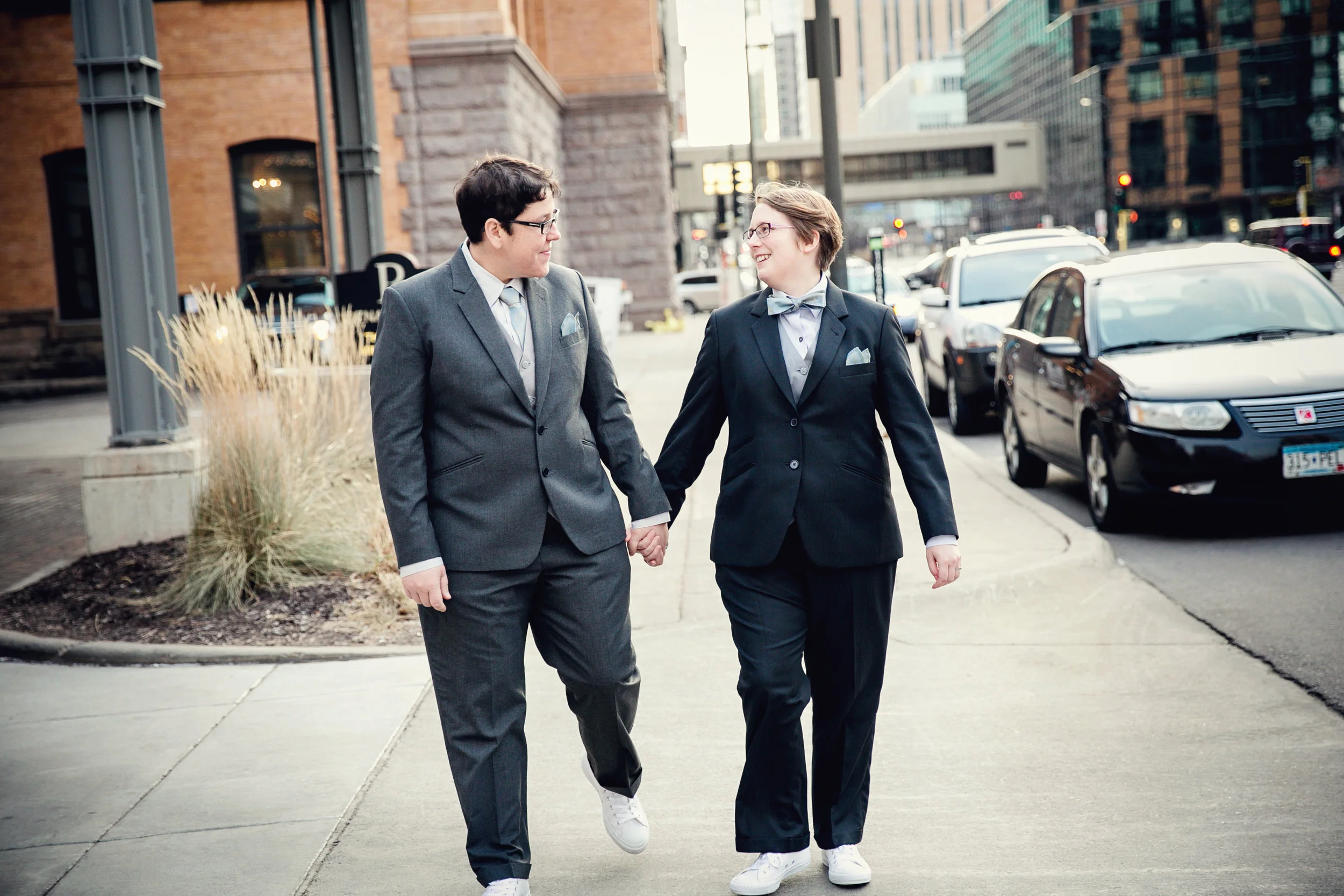 Couple strolling down sidewalk holding hands