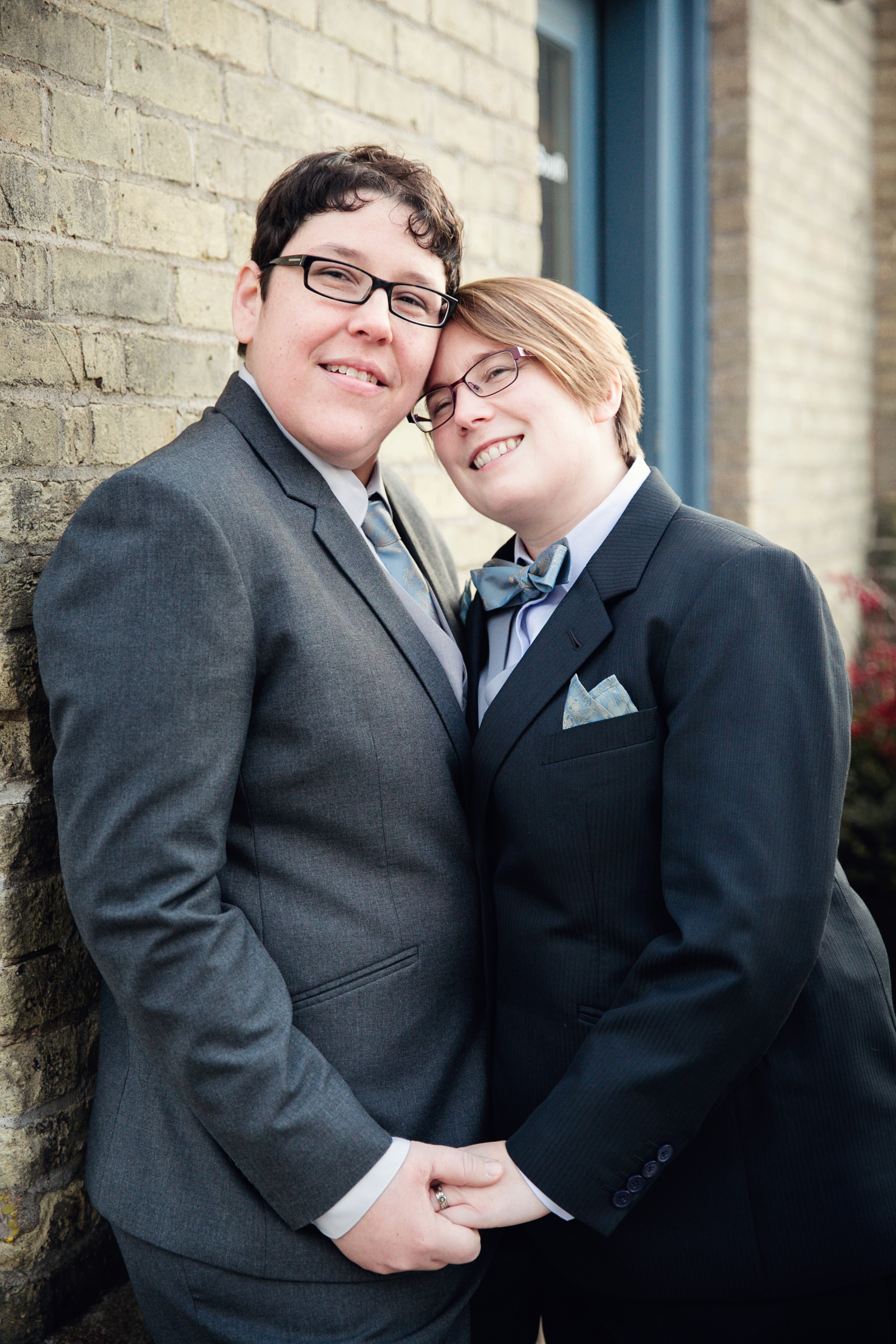 Couple posing against brick wall