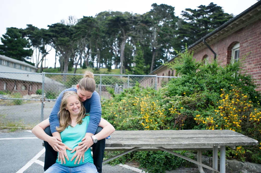 Same-sex maternity photos, holding belly
