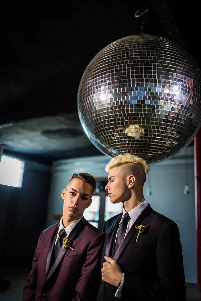 Same-sex couple at their wedding with a disco ball