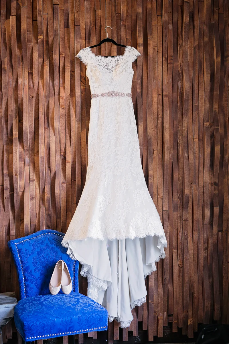 wedding gown hanging next to sparkly bridal flats