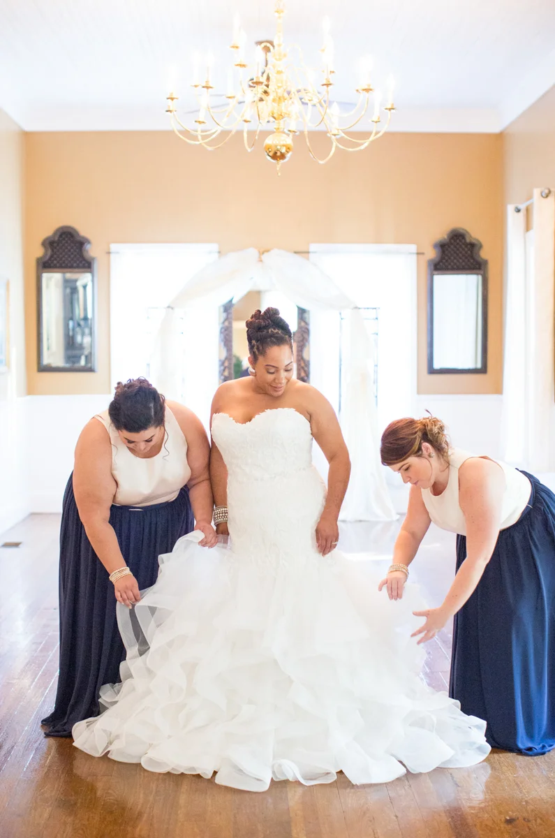 Bride and bridesmaids fixing gown