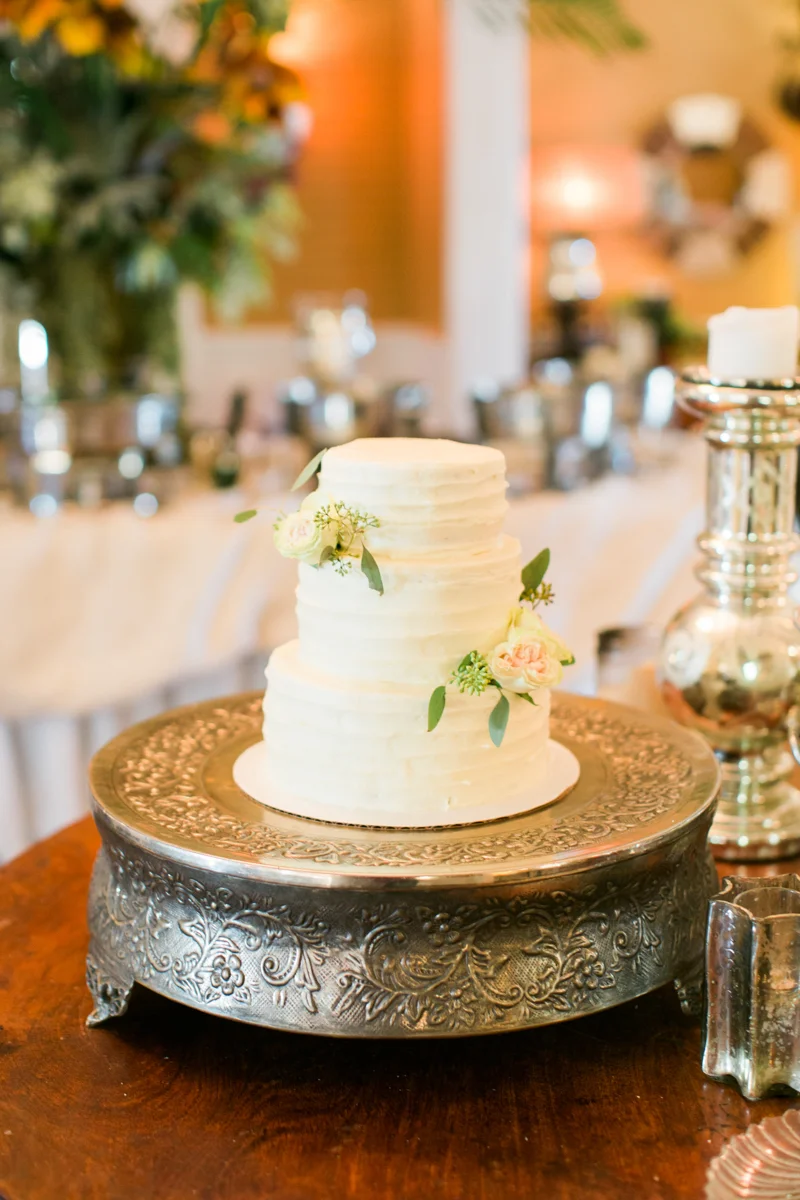 two tiered white wedding cake with roses on