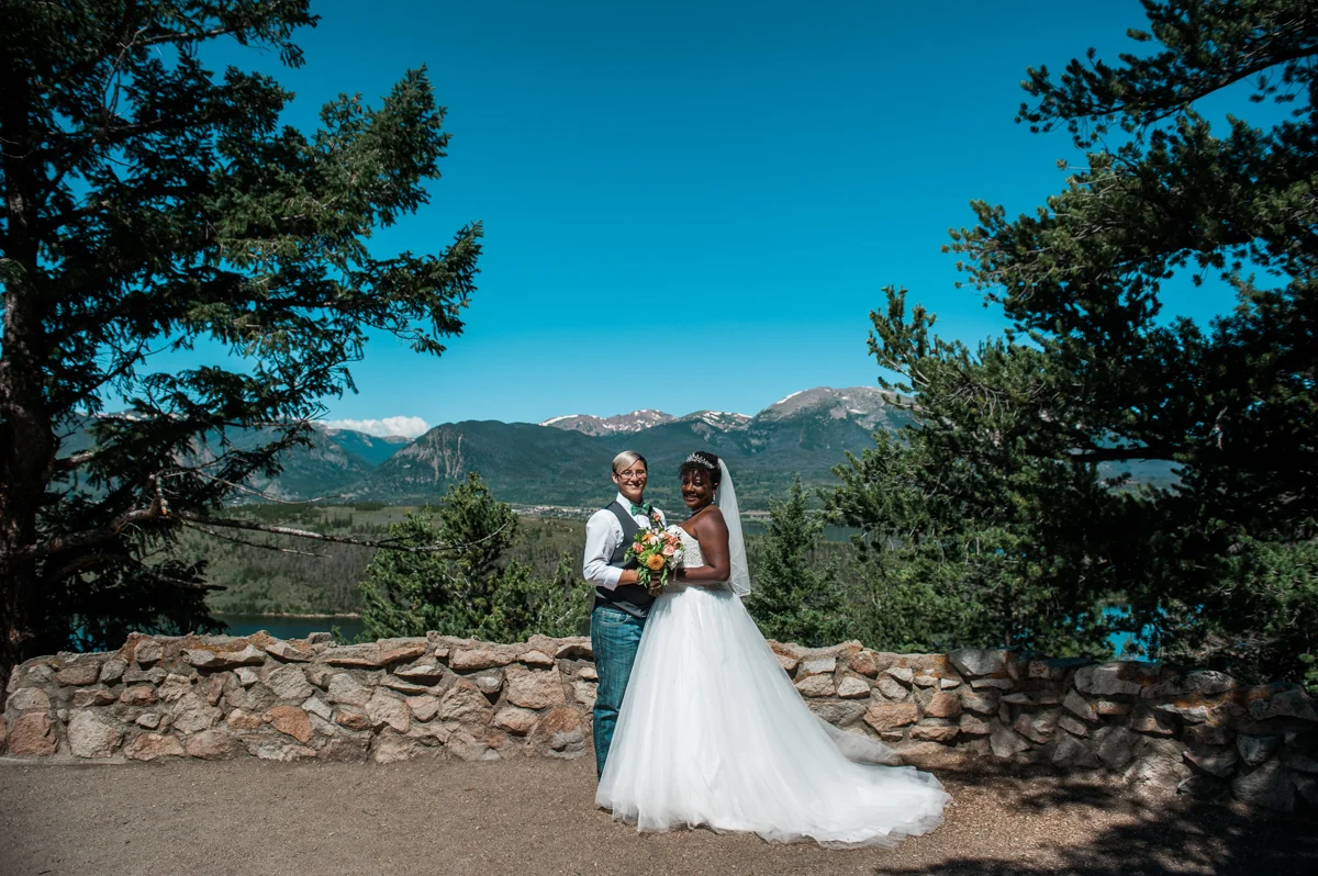 mountain elopement brides pose in front of skyline