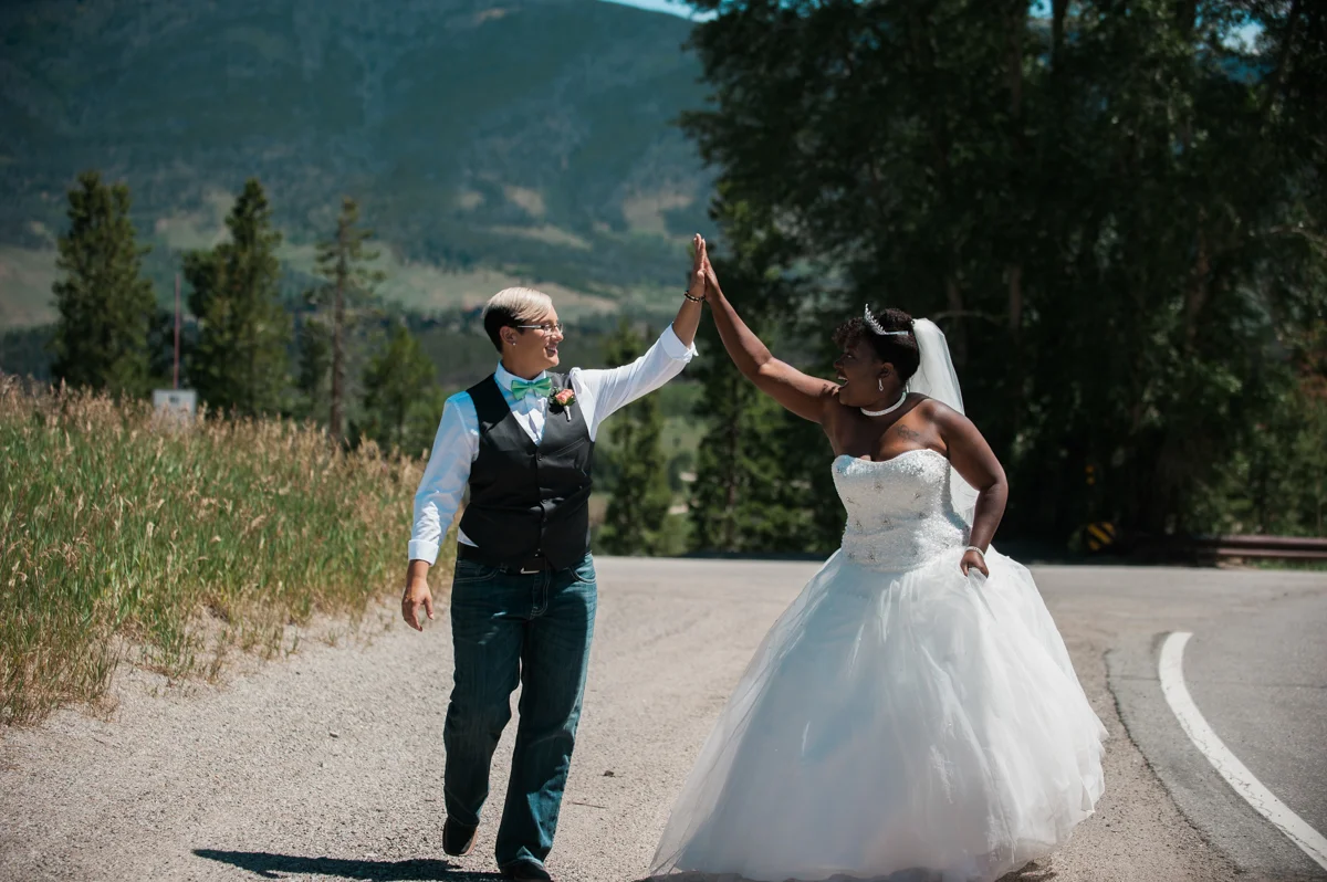 mountain elopement hands together in the air