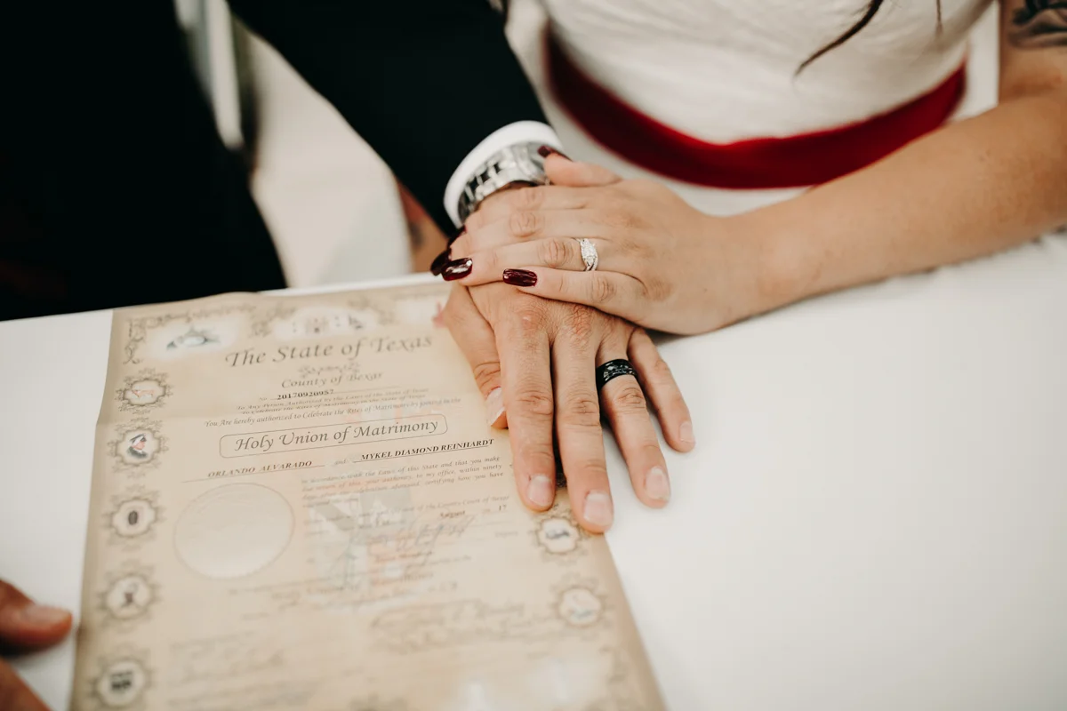 San antonio garden wedding hands with wedding rings and invitations