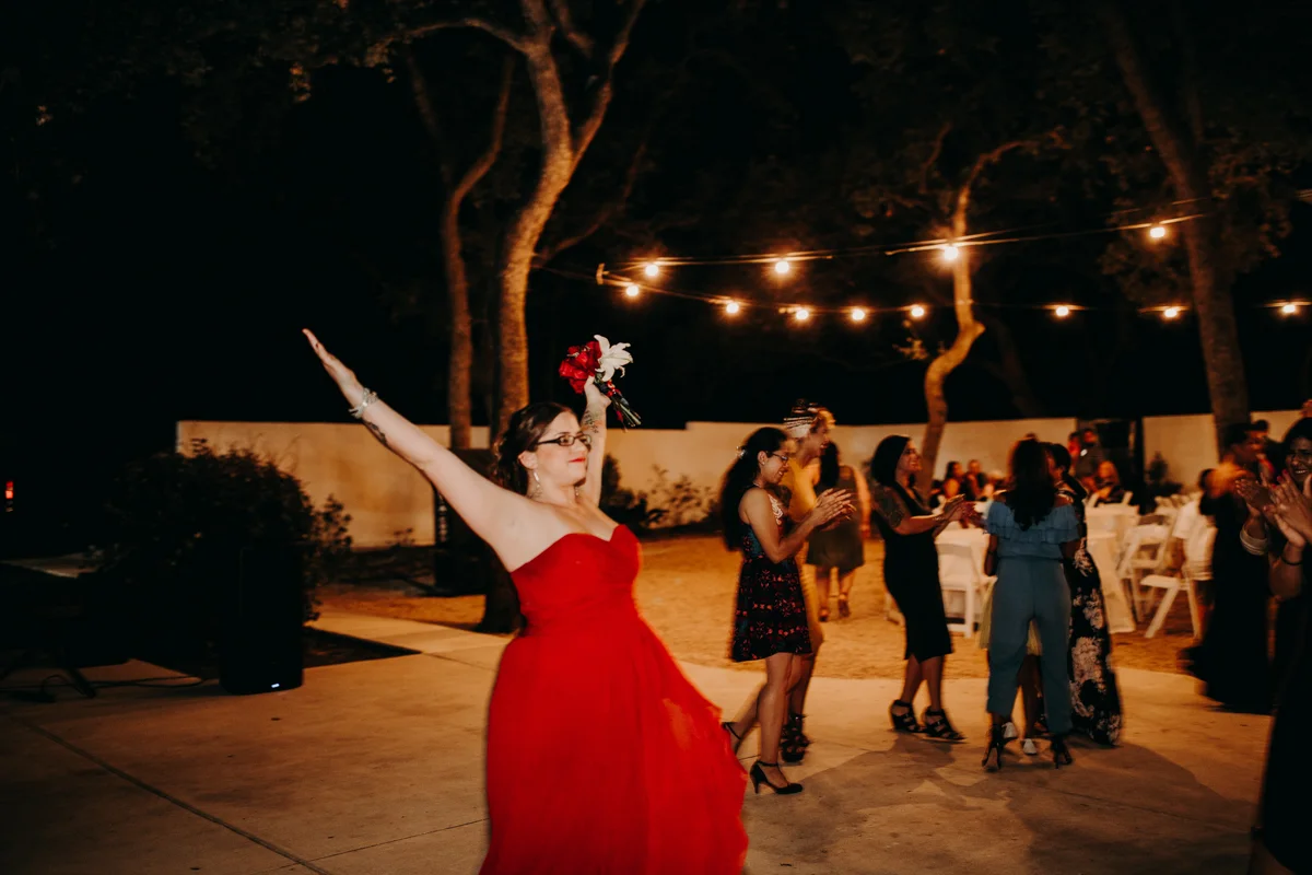 San antonio garden wedding bridesmaid with bouquet raised victoriously