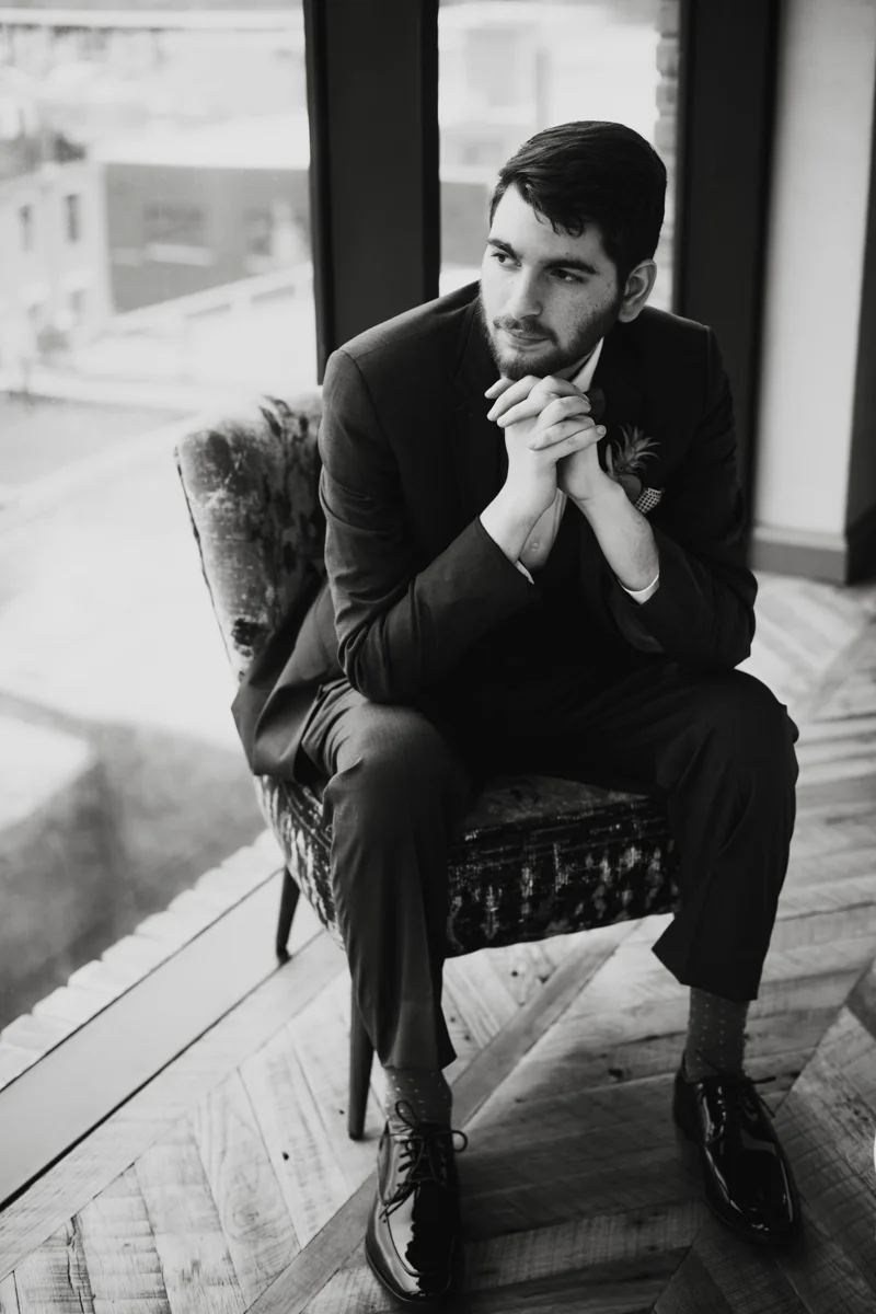 williamsburg hotel wedding shoot groom posing in chair