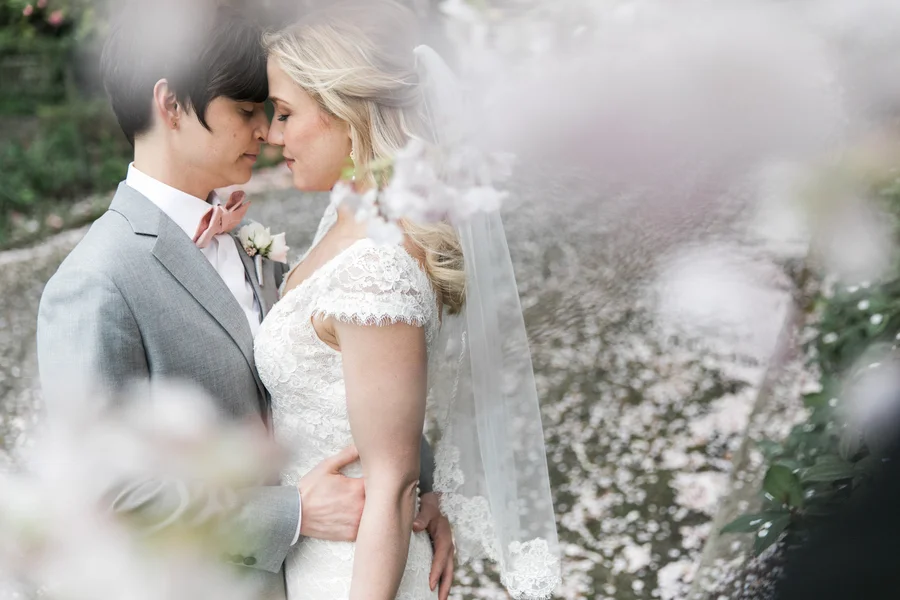 ARIN AND KATIE DOWNTOWN SEATTLE WEDDING EMBRACE UNDER BLOSSOMS
