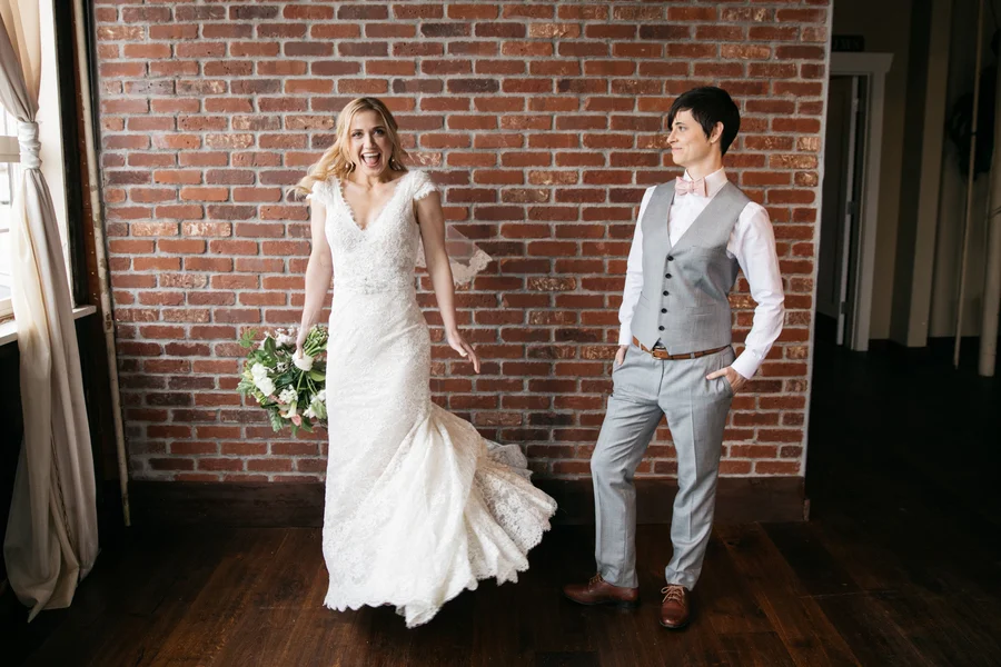 ARIN AND KATIE DOWNTOWN SEATTLE WEDDING CANDID COUPLE IN FRONT OF BRICK WALL