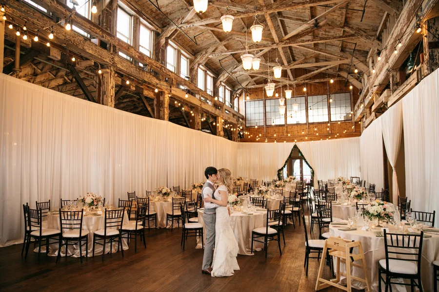  ARIN AND KATIE DOWNTOWN SEATTLE WEDDING couple kissing in empty reception venue