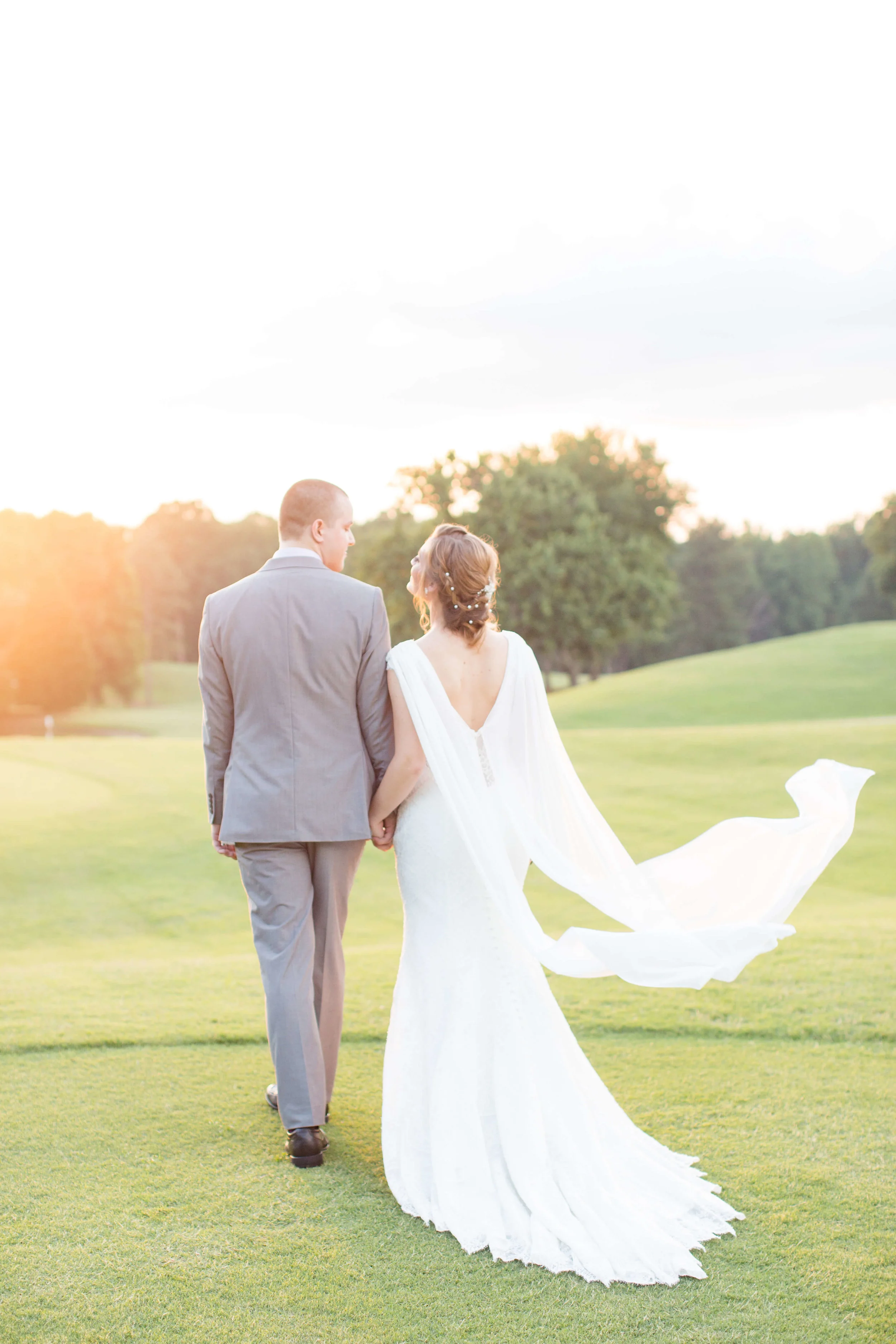 Newlywed couple holding hands and walking into the sunset Jessica Hunt Photography Southeast US Weddings