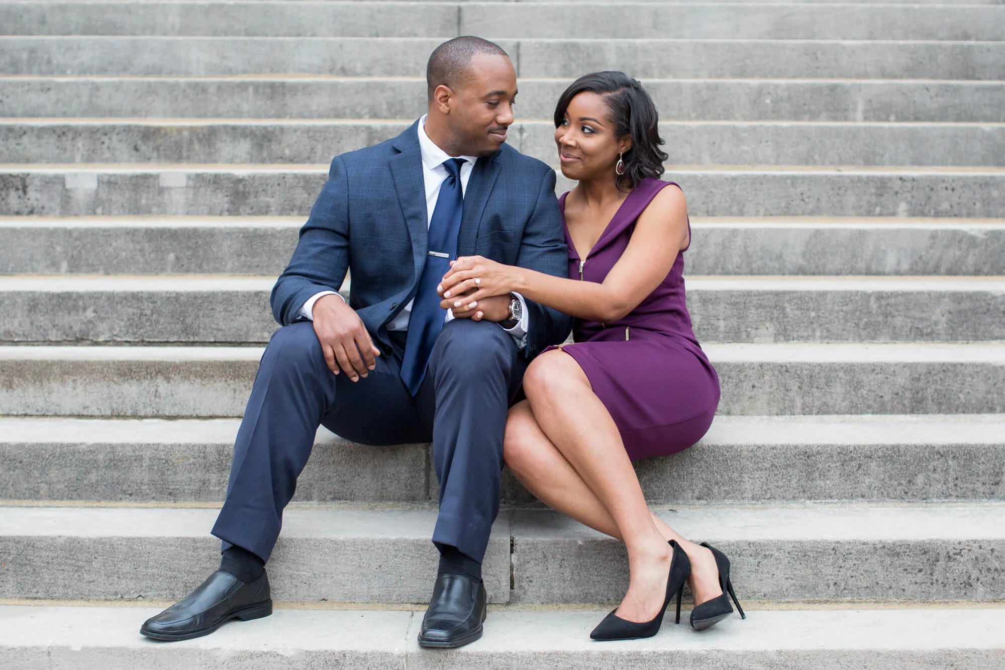 Engaged couple sitting together on concrete steps Jessica Hunt Photography Southeast US Weddings