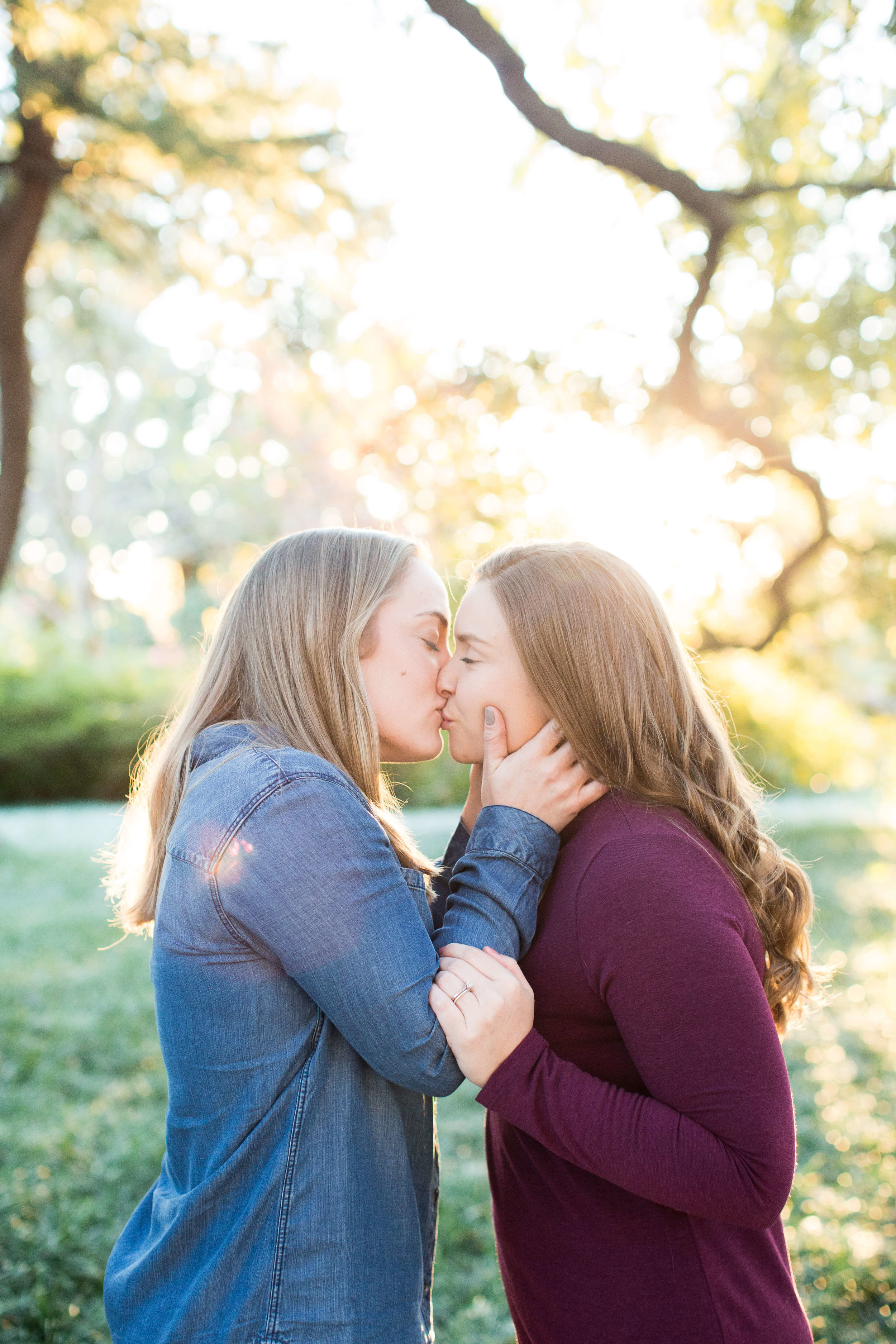 Engaged couple kissing outdoor under a beautiful tree Jessica Hunt Photography Southeast US Weddings