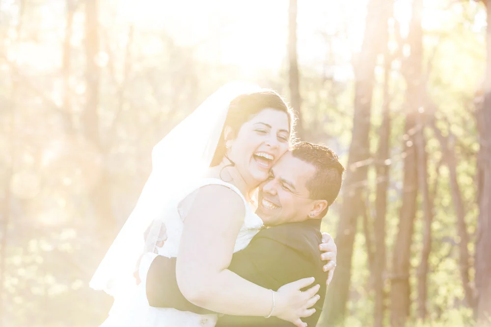Groom lifting veiled bride into the air in a forest in Montana Meera Graham Photography