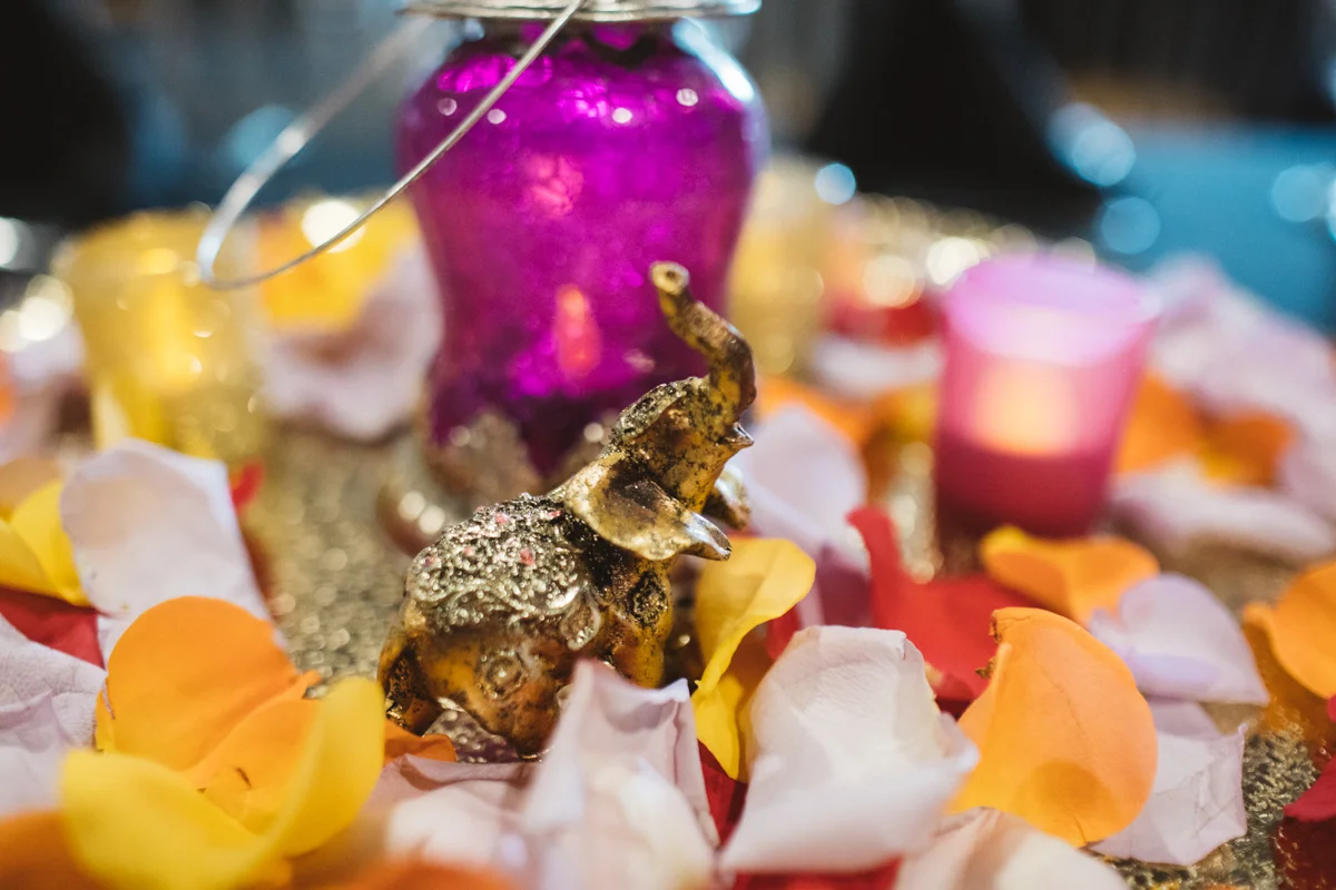 DENVER SAME-SEX INDIAN WEDDING TABLE WITH SMALL ELEPHANT STATUE AND FLOWER PETALS