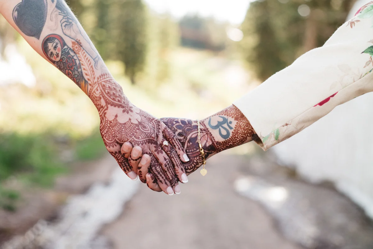 DENVER SAME-SEX INDIAN WEDDING BRIDES HOLDING HENNA-COVERED HANDS