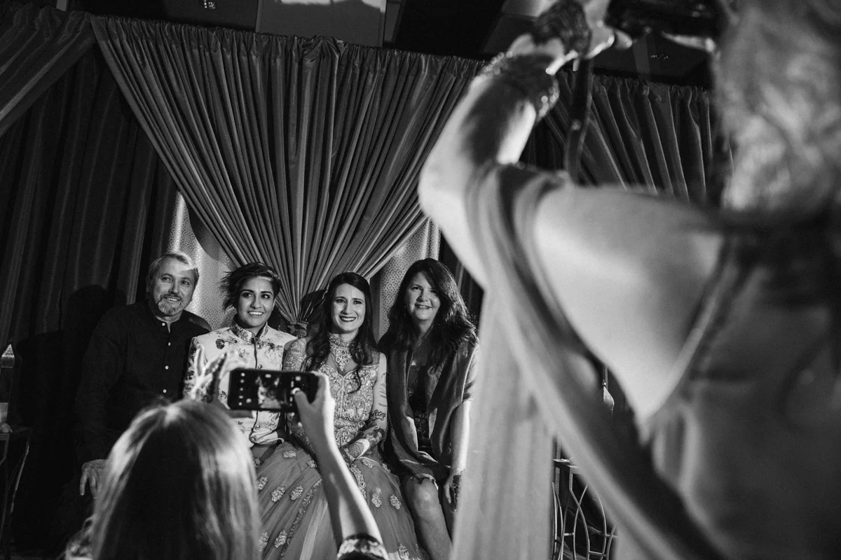 DENVER SAME-SEX INDIAN WEDDING COUPLE AND PARENTS GETTING PICTURES TAKEN BY GUESTS
