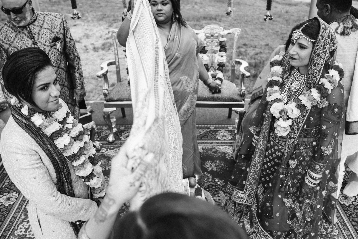Denver Same-Sex Indian Wedding matrons of honor holding cloth between brides for pravesh