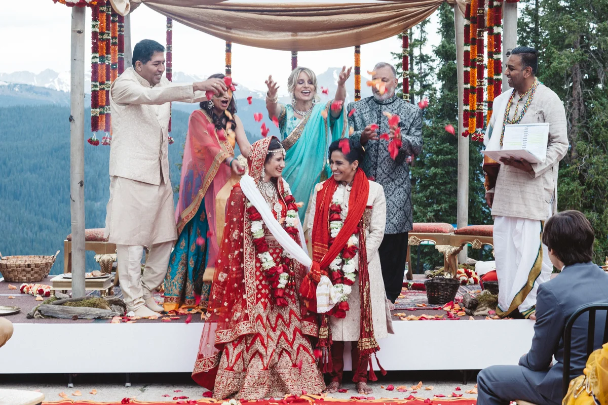 Denver Same-Sex Indian Wedding couple being showered with flower petals by parents