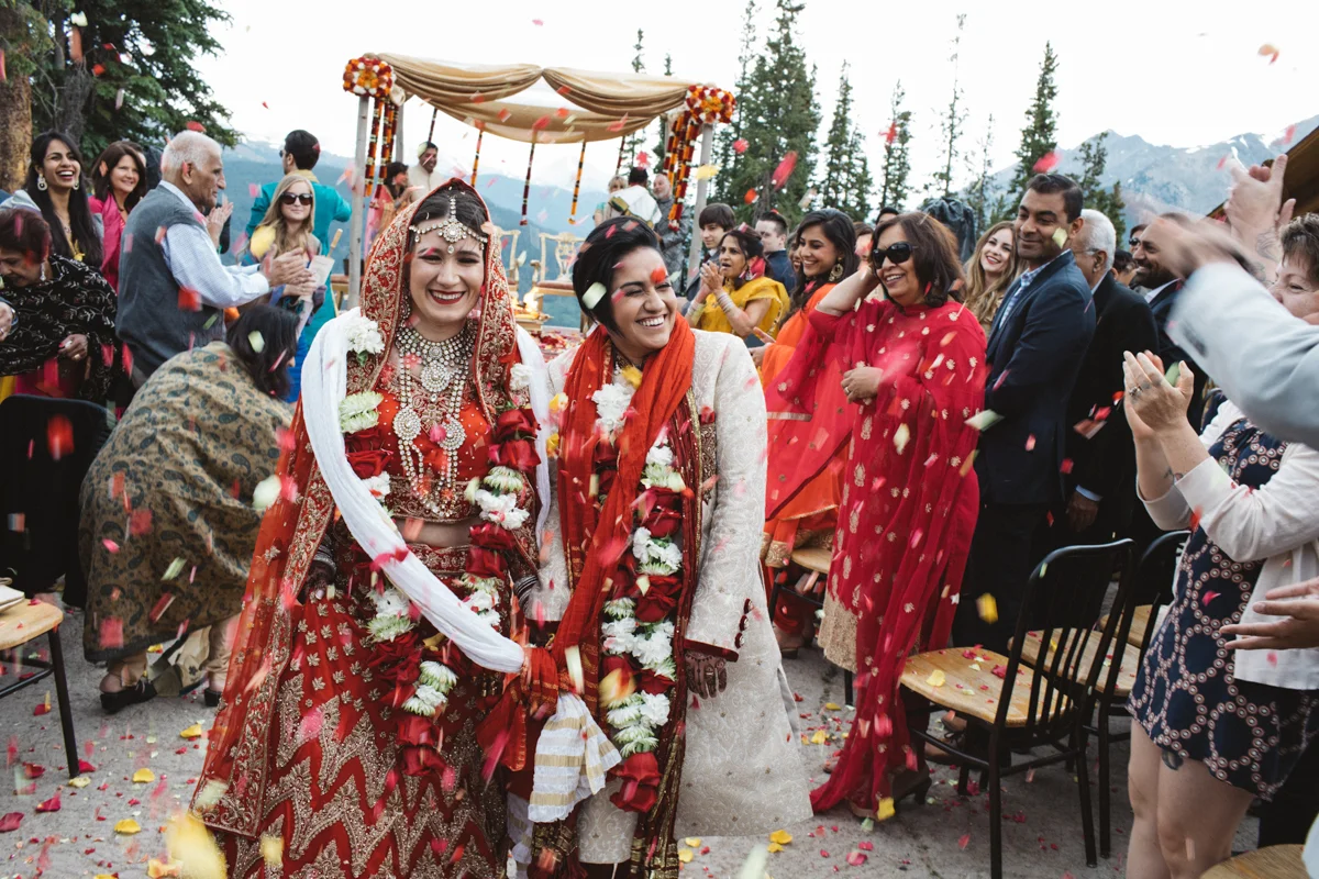 denver same-sex indian wedding couple leaving ceremony being showered in flower petals