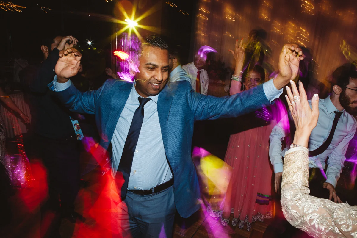 denver same-sex indian wedding guests dancing with blurry camera affect
