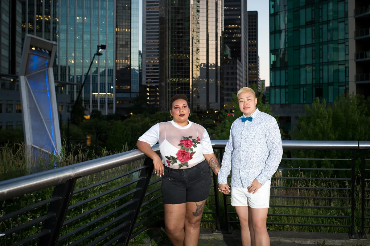 vancouver "just because" photo shoot pose on bridge holding hands in front of glass buildings