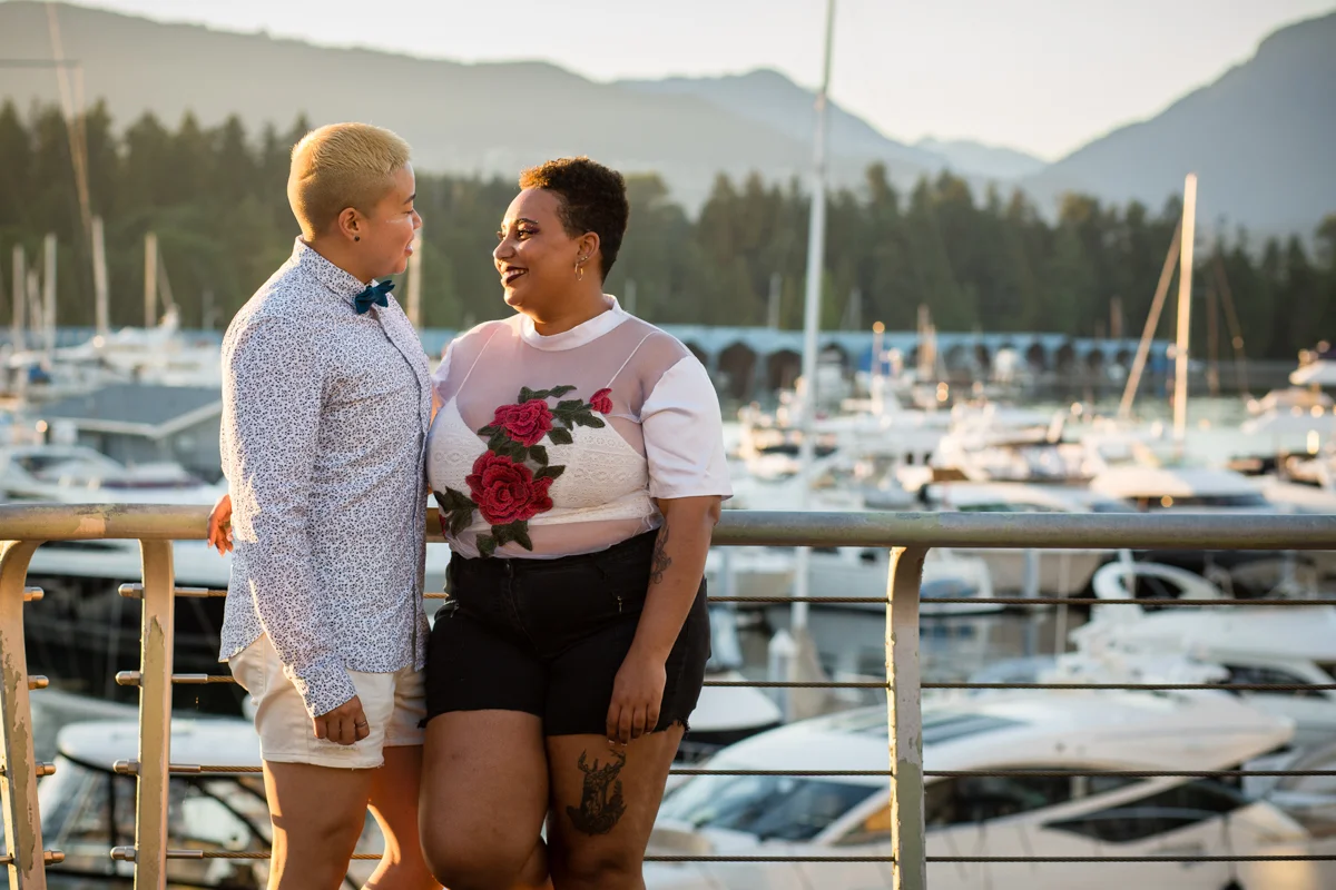 vancouver "just because" photo shoot couple smiling on bridge in front of boat-filled docks