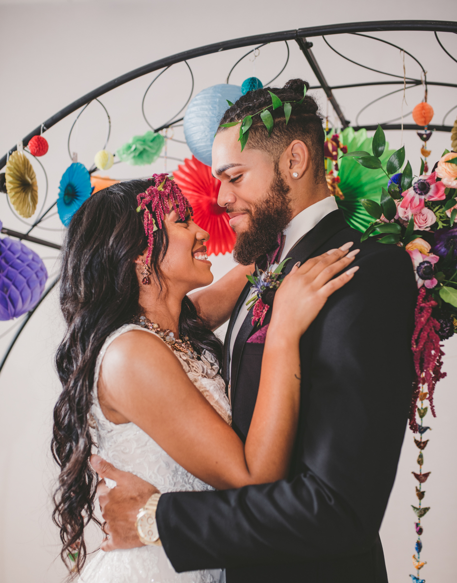 we are young worth the wait studios couple smiling at one another under arch