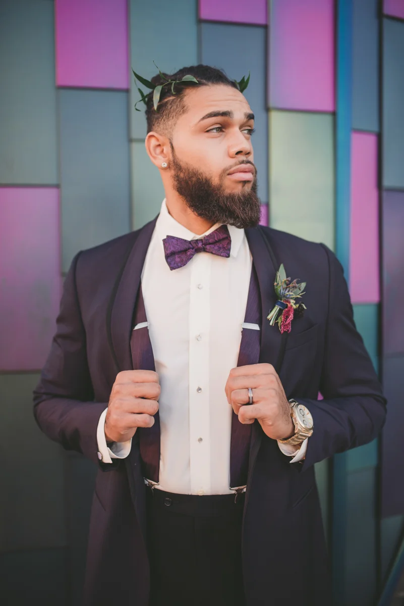 we are young worth the wait studios groom posing in front of stained glass