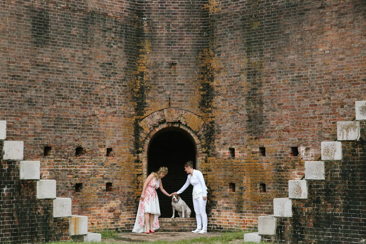 gulf shores destination wedding couple at old building patting buck jones's head