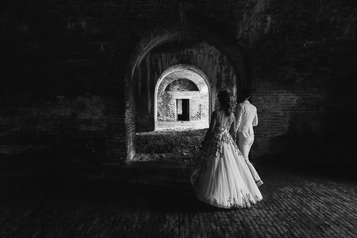 gulf shores destination wedding couple walking through brick arches