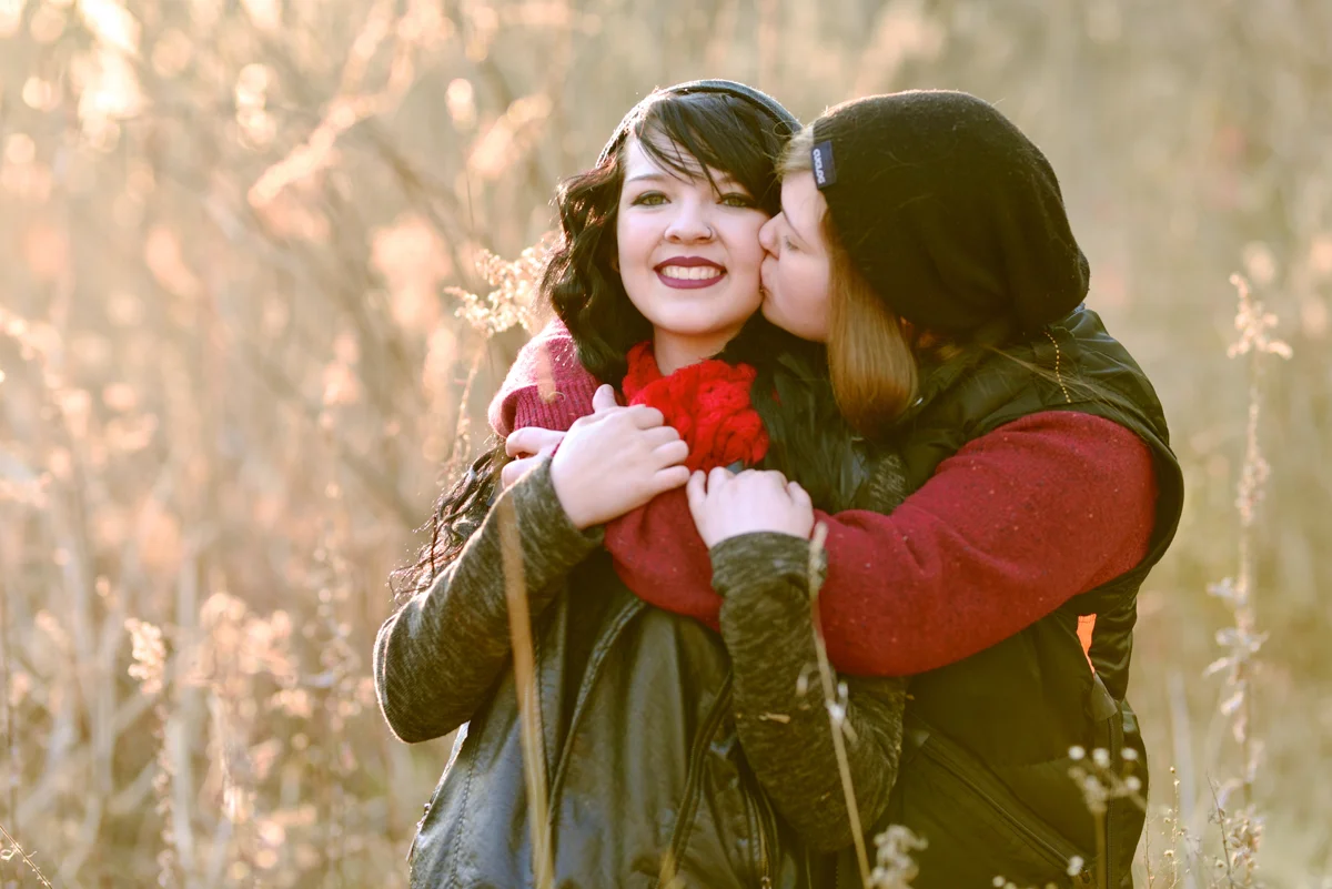 lafayette indiana engagement session megan kissing alexis's cheek in field