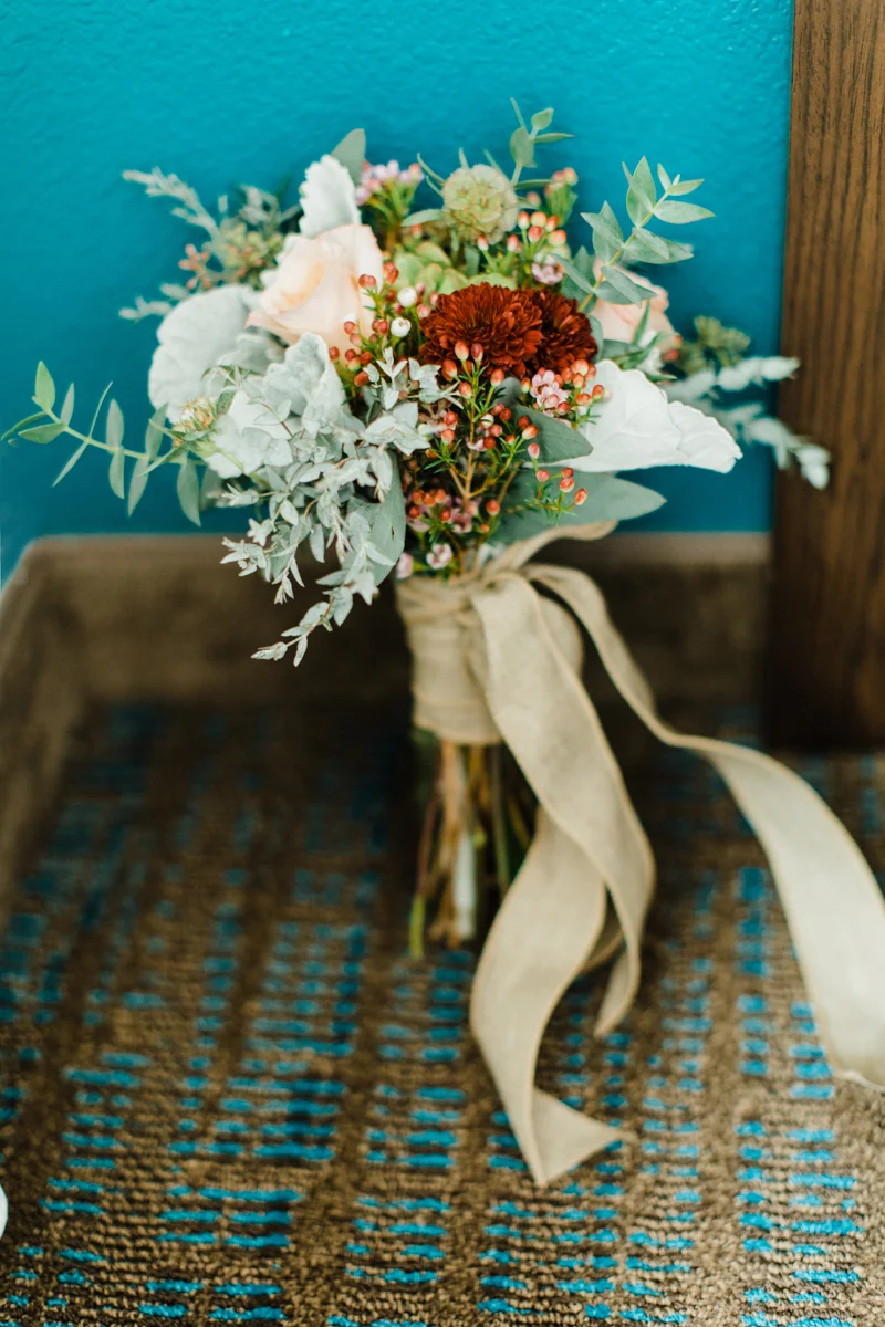belmont park engagement session san diego bouquet of flowers resting against wall