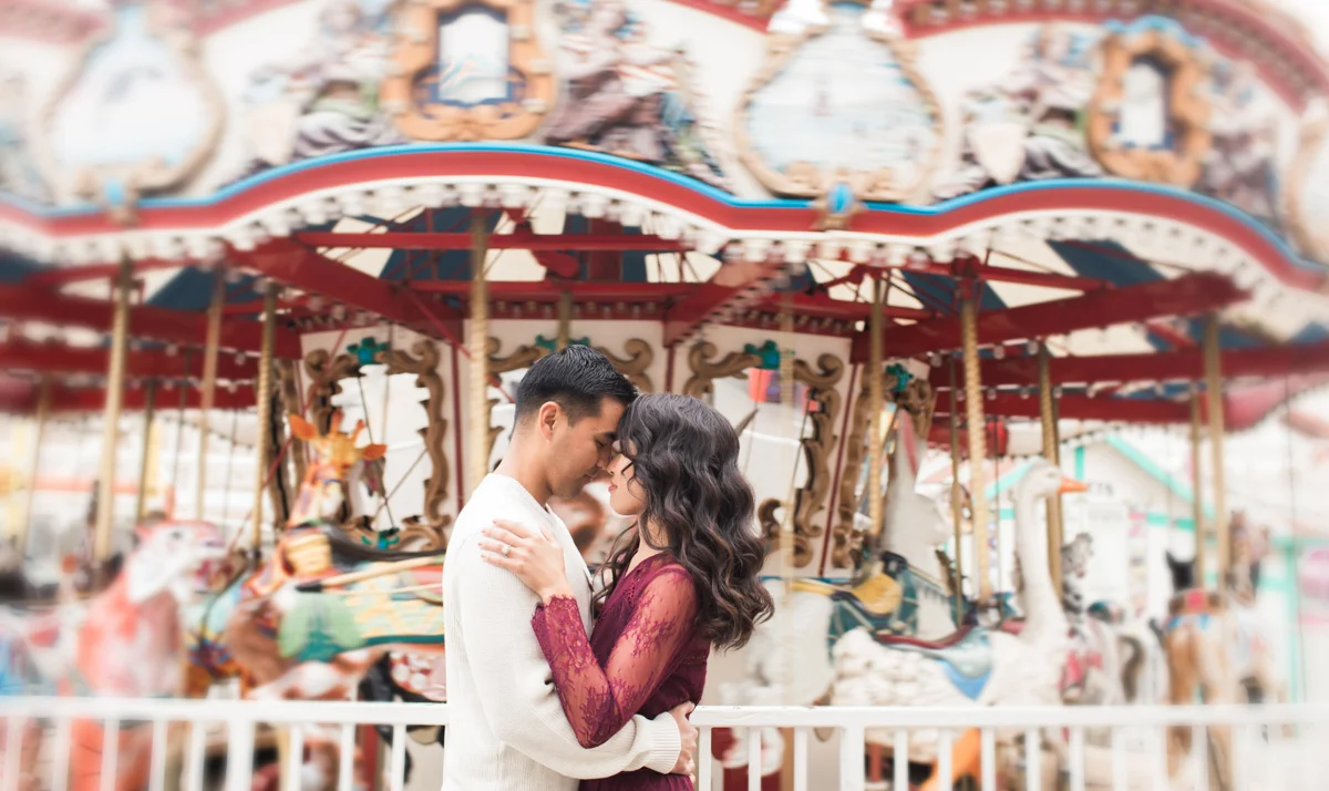 belmont park engagement session san diego embrace in front of merry-go-round