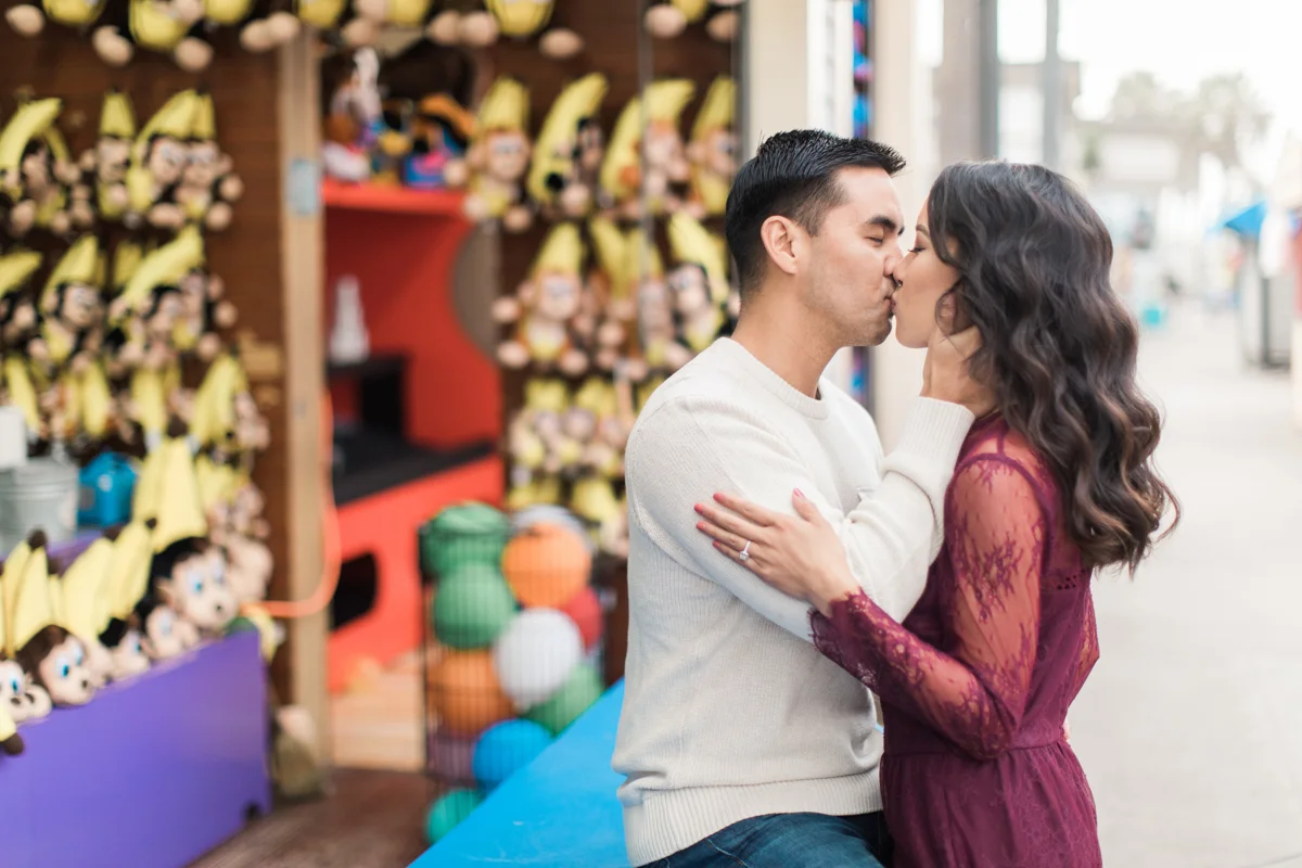 belmont park engagement session san diego kiss at game booth