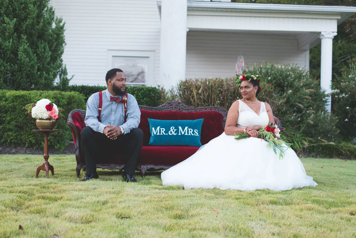 B ohemian Styled Shoot couple on sofa outside with pillow reading "mr. and mrs."