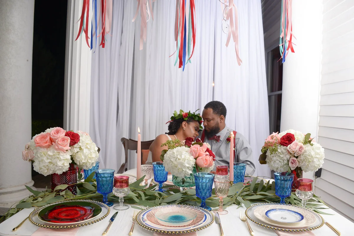 B ohemian Styled Shoot embrace at table under ribbon decorations